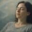 Femme détendue en séance d'hypnose, yeux fermés, dans une ambiance douce - illustration poétique de l'apaisement de la douleur fibromyalgique