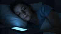 Une personne endormie perturbée par la lumière bleue de son téléphone